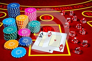 A pair of aces, casino chips and dice on a red gambling table in a casino. Set for playing poker, roulette, craps or