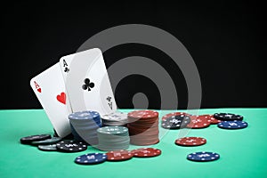 A pair of aces on a deck of playing cards. Poker playing chips on a green table. Online gambling. Addiction. Playing cards