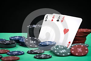 A pair of aces on a deck of playing cards. Poker playing chips on a green table. Online gambling. Addiction. Playing cards