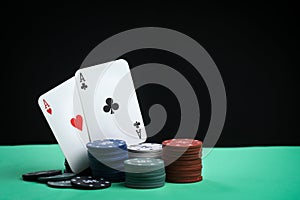 A pair of aces on a deck of playing cards. Poker playing chips on a green table. Online gambling. Addiction. Playing cards