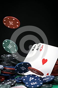 A pair of aces on a deck of playing cards. Poker playing chips on a green table. Online gambling. Addiction. Playing cards