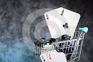 A pair of aces, hearts and diamonds, on a deck of playing cards. Poker playing chips on a dark and blue background.