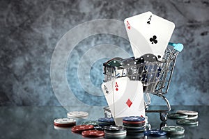 A pair of aces, hearts and diamonds, on a deck of playing cards. Poker playing chips on a dark and blue background.