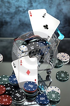 A pair of aces, hearts and diamonds, on a deck of playing cards. Poker playing chips on a dark and light blue background.
