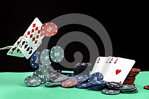 A pair of aces, hearts and diamonds, on a deck of playing cards. Poker playing chips on a green table. Online gambling. Addiction.