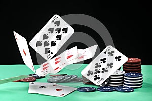 A pair of aces, hearts and diamonds, on a deck of playing cards. Poker playing chips on a green table. Online gambling. Addiction.