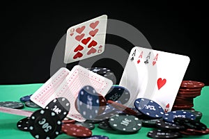 A pair of aces, hearts and diamonds, on a deck of playing cards. Poker playing chips on a green table. Online gambling. Addiction.