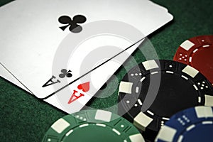 A pair of aces with a pile of poker chips