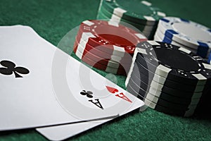 A pair of aces with a pile of poker chips