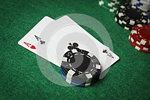 A pair of aces with a pile of poker chips