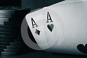 A pair of aces and poker chips, black and white photo. Ace of hearts and ace of diamonds. Nuts hand a pair of aces to