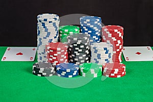Pair aces and poker chips stack on green table