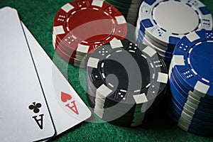 A pair of aces on the table with poker chips