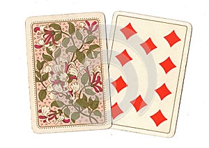 A pair of antique playing cards with the ten of diamonds revealed.
