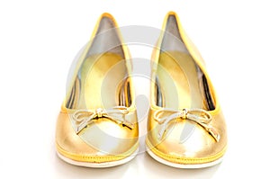 Pair of ballet flats in golden colour on white background.