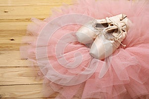 Pair of ballet shoes pointes on wooden floor