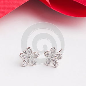 A pair of beautiful 925 sterling silver earrings in flower shape decorate with cubic zirconia photo