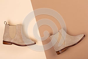 A pair of beige women shoes lies on a beige and brown background, the concept of fashion