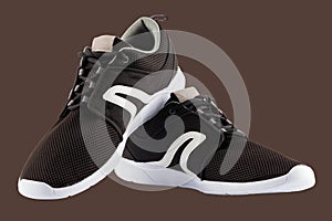 pair of black airmesh summer walking lightweight shoes isolated on brown background