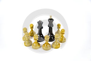 A pair of black chess pieces surrounded by white pawns - isolated on a white background.