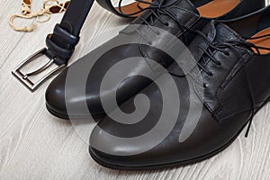 Pair of black leather men`s shoes and leather belt for men on gr