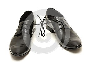 Pair of black man shoes tied together on white