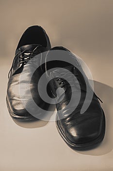 Pair of black old shoes on a light background