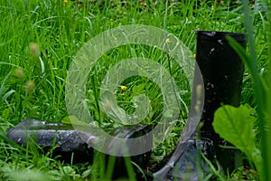 A pair of black rubber boots in the green grass