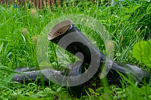 A pair of black rubber boots in the green grass