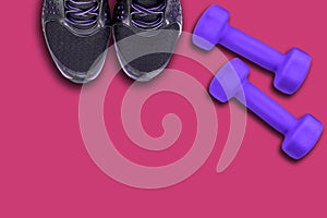 Pair of black shoe, sneaker and dumbbells of color ultra violet on a pink / purple background