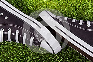 Pair of black sneakers on the green grass