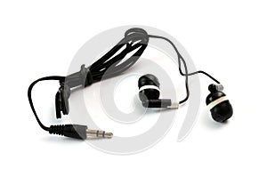 A pair of black TRS tip ring sleeve earphones bound by a cable tie white backdrop