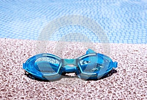 Pair of blue goggles by the pool