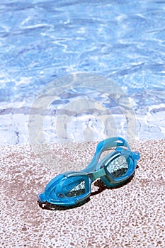 Pair of blue goggles by the pool