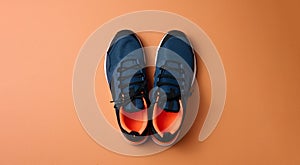 Pair of blue textile sneakers on orange background, top view