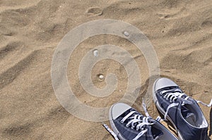 Blue unlaced sneakers on beach