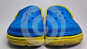 a pair of blue and yellow sandals with holes