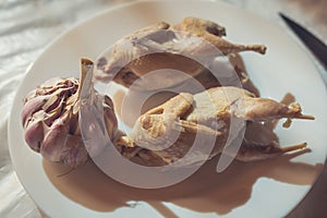 Pair of boiled quails lie on a white plate