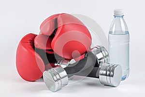 A pair of boxing gloves and dumbbells and a bottle of water. photo