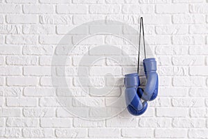 Pair of boxing gloves hanging on brick wall