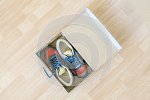 pair of brand new shoes in shoe cartoon box on wooden floor f