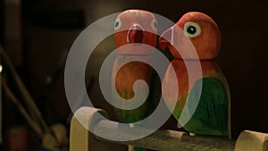 A pair of bright lovebirds, a wooden comic toy