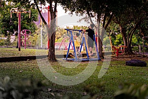 A pair of brothers playing in a playingroung in the twilight