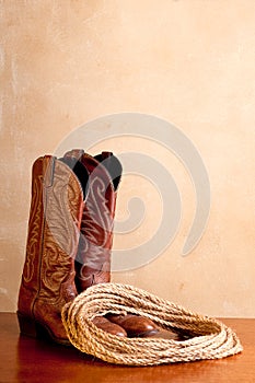 A pair of brown cowboy boots and rope photo