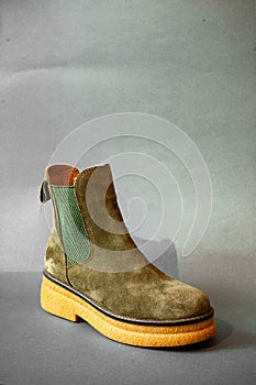 a pair of brown and green sued boots with wood soles