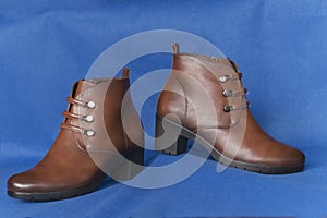 Pair of brown leather boots on blue background