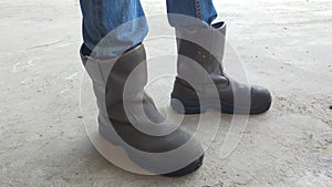 A pair of brown man safety shoes and jeans