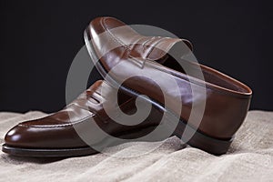 Pair of Brown Stylish Leather Penny Loafer Shoes Placed On Mesh Surface