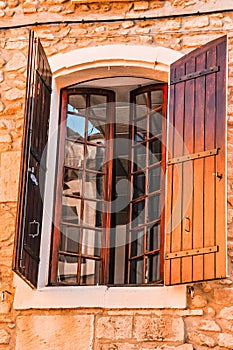 Pair of brown, wood, window shutters, on a 1300`s century stone and mortar building