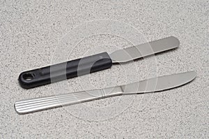 A pair of butter bread spread knives one with black plastic handle